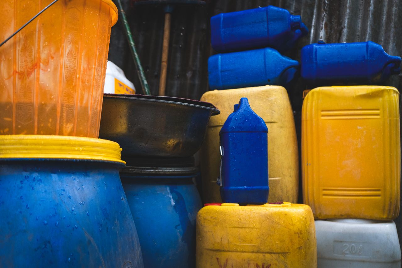 Vibrant assortment of yellow, blue, and orange plastic containers stacked outdoors in Ethiopia.