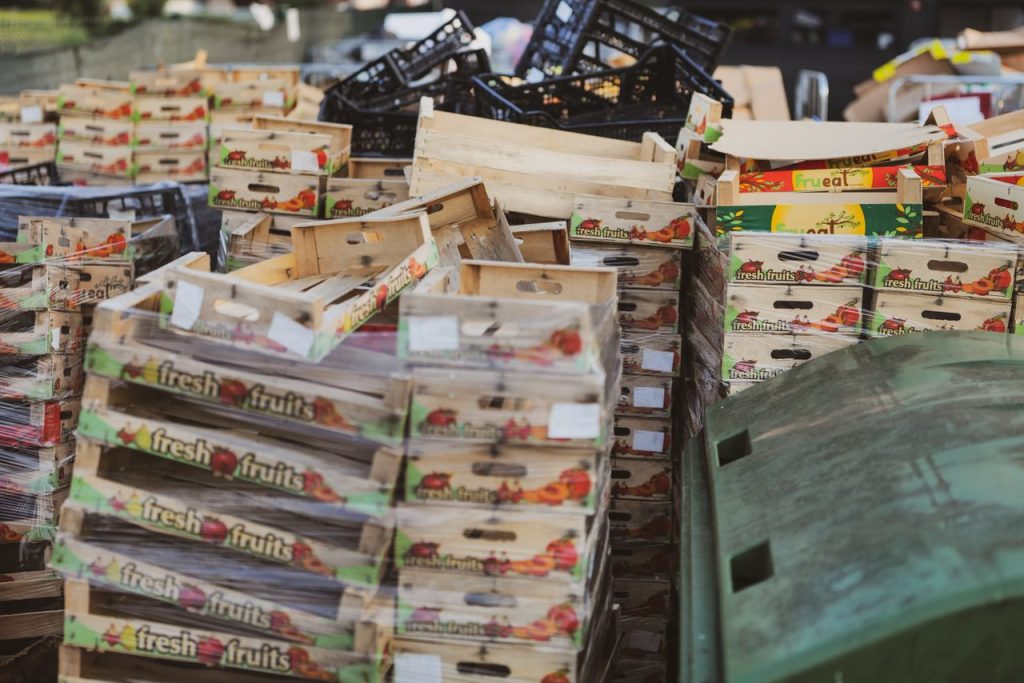 Piles of wooden fruit boxes in an outdoor market area, ideal for food or recycling themes.